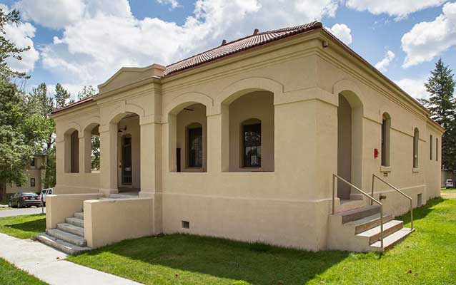 Tan stucco building with red tile roof.