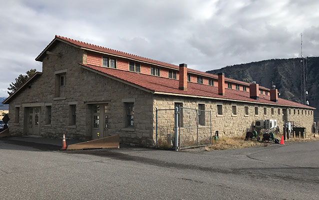 Long stone building with red tile roof.