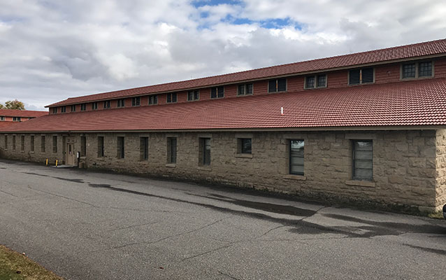 Long stone building with red tile roof.