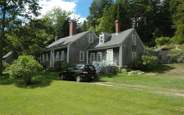 House facade and north elevation facing southwest, with barn at left