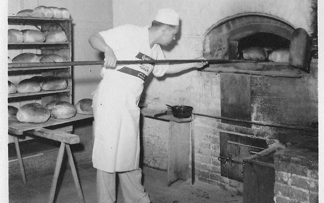 man taking bread out of the oven at Hahn's bakery