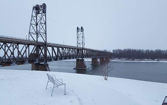 a steel bridge over river in snow. 