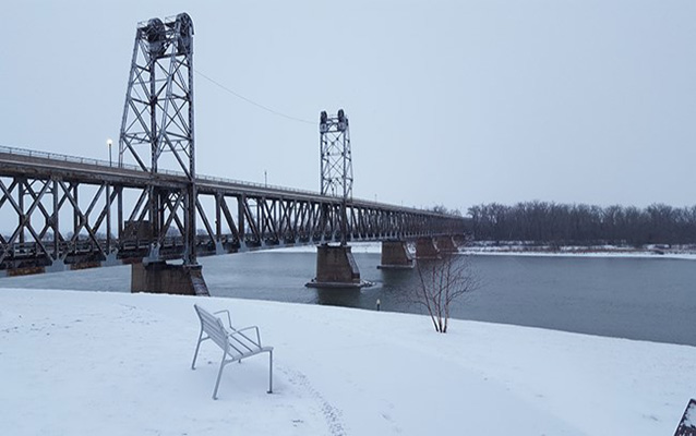 a steel bridge over river in snow.