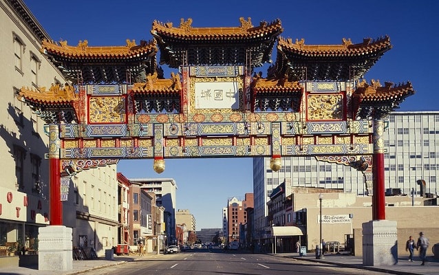 Contemporary photograph of the colorful friendship arch with buildings in the background. 
