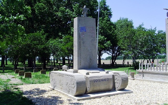 Contemporary photo of cement monument in the shape of a tank with headstone on top. Contemporary photo of cement monument in the shape of a tank with headstone on top.