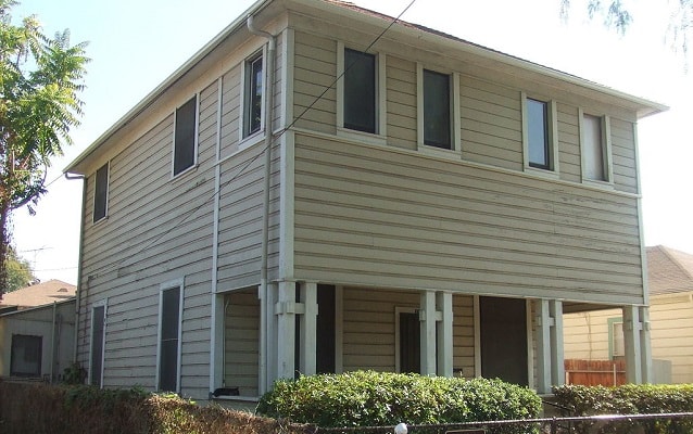 Square two-story house with overhang. 