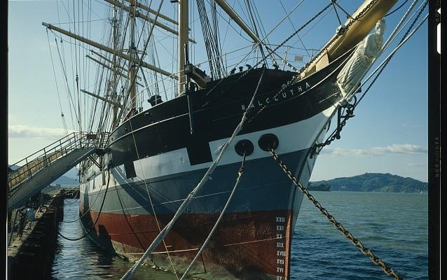 Photo of the font of the ship with masts, boat in the ocean. 