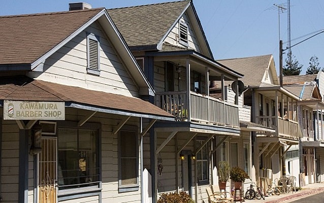 Modest one and two-story house lining the street. 