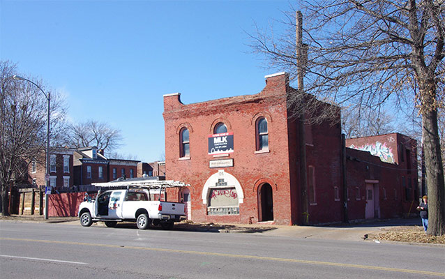 Two story brick building, exterior, looking southwest at east façade and north elevation