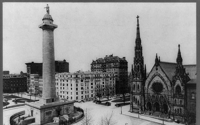 Washington Monument in a square in front of a church. 