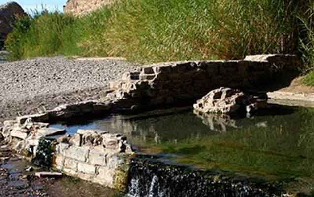 ruins of bricks around hot spring, grass in background ruins of bricks around hot spring, grass in background