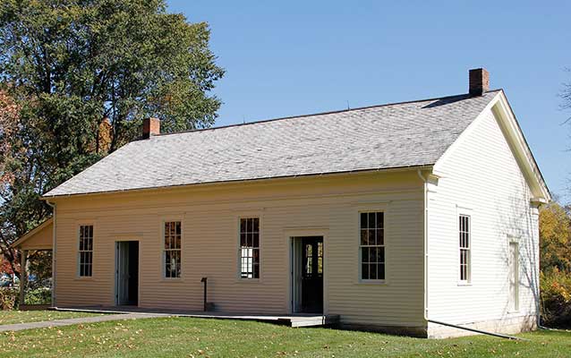Two doorways, one on either side, of a broad white wood frame building divides the sexes. Two doorways, one on either side, of a broad white wood frame building divides the sexes.