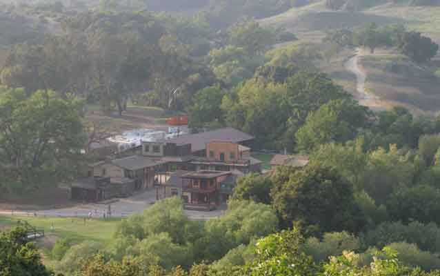 western themed buildings surrounded by trees and hills western themed buildings surrounded by trees and hills