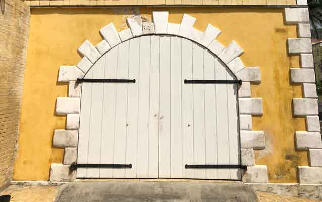 a white door with a rounded top on a yellow building