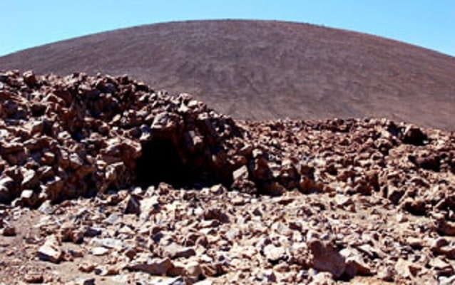 Image of rock structure with hill in background. Photograph by Justin Shearer, Flickr