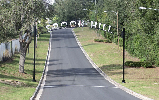 Entrance sign above road saying “Spook Hill” 