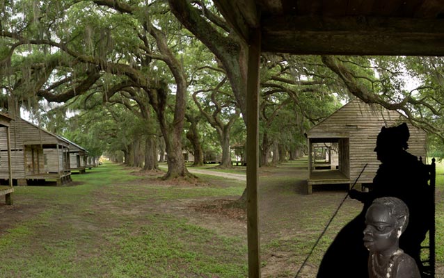 a silhouette of a woman sitting alongside a southern plantation in louisiana and an african bust