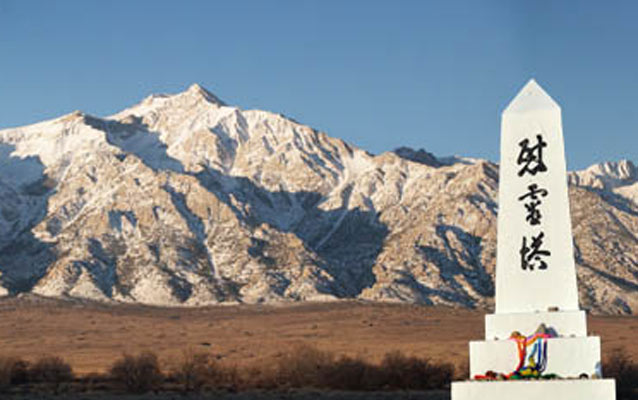 the monument at Manzaner with mountains in the background and a bright blue sky