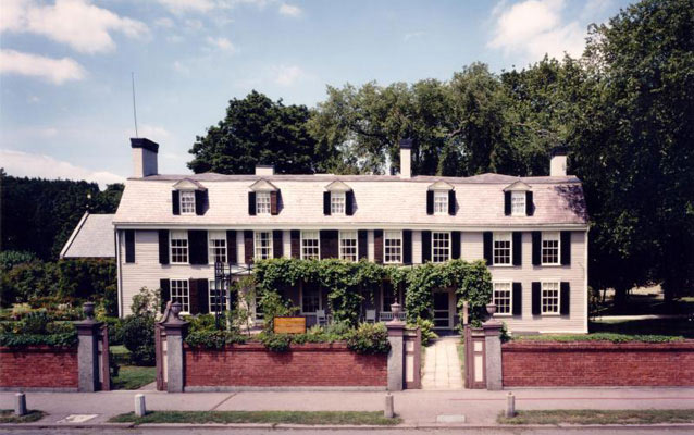 A long, clapboard house, painted white with dark window shutters. A long, clapboard house, painted white with dark window shutters.