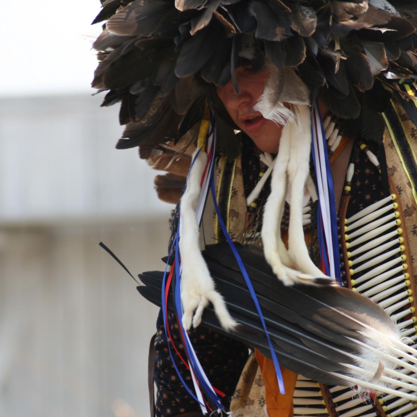 Man in traditional American Indian Dress Dancing.