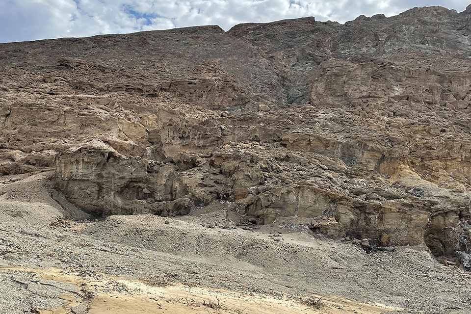 Brown mountainside with streams of waterfalls rushing down.