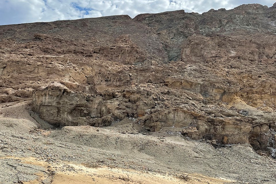 Brown mountainside with streams of waterfalls rushing down.