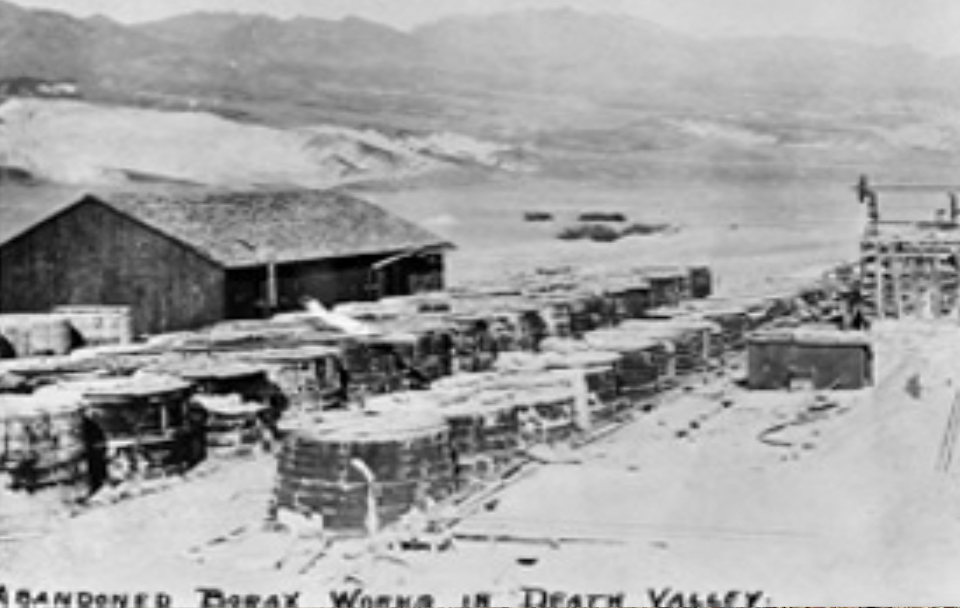 Cylindrical tanks with building and desert mountains.