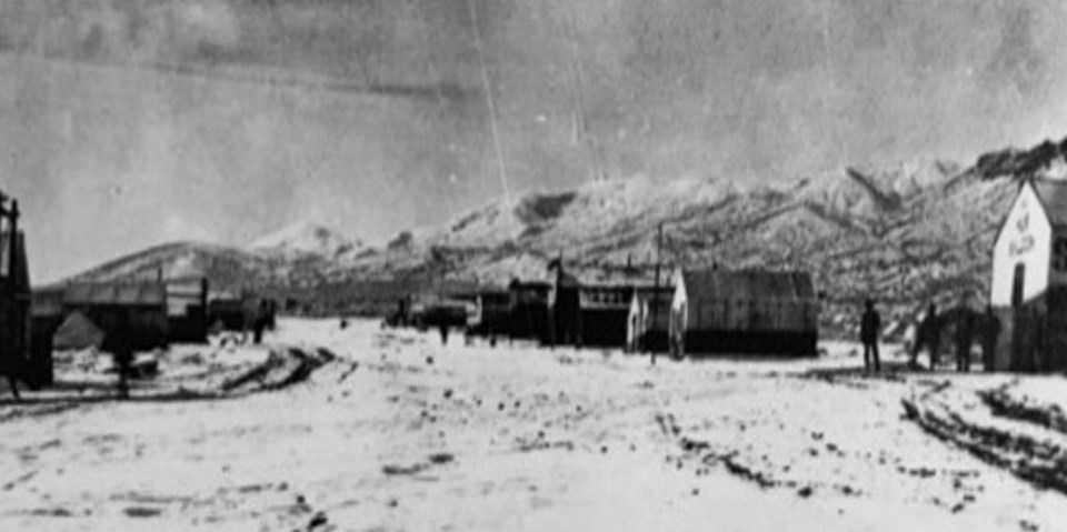 Tents and wooden buildings with snow on the ground