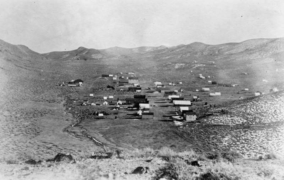 Buildings scattered in desert valley.