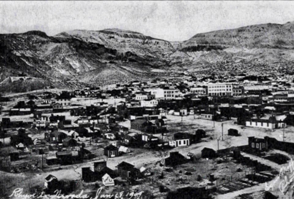 Buildings and streets with mountains in background.