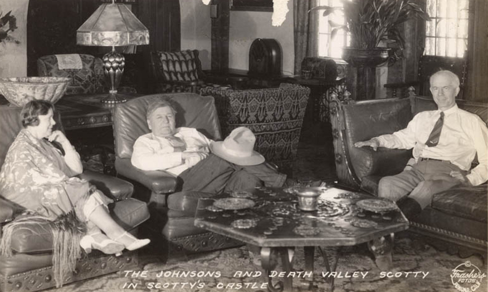 Two men and a woman sit in a furnished room.