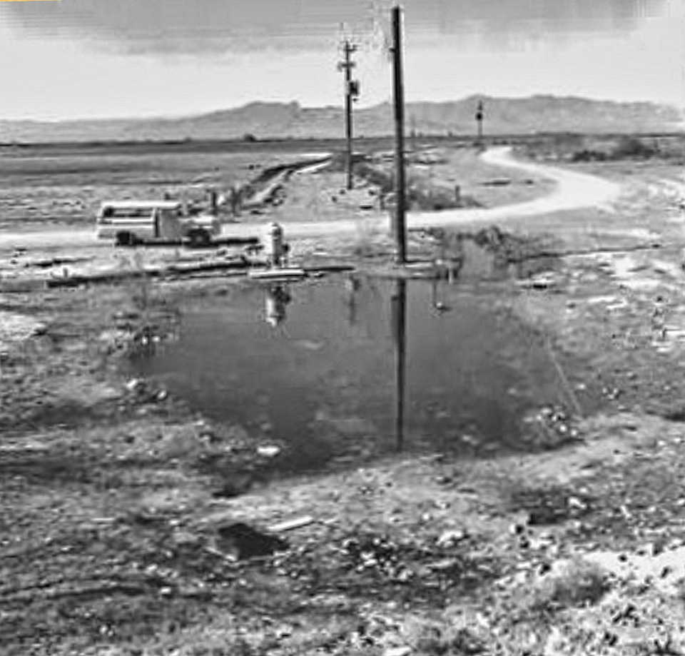 A truck and man next to pond with power lines