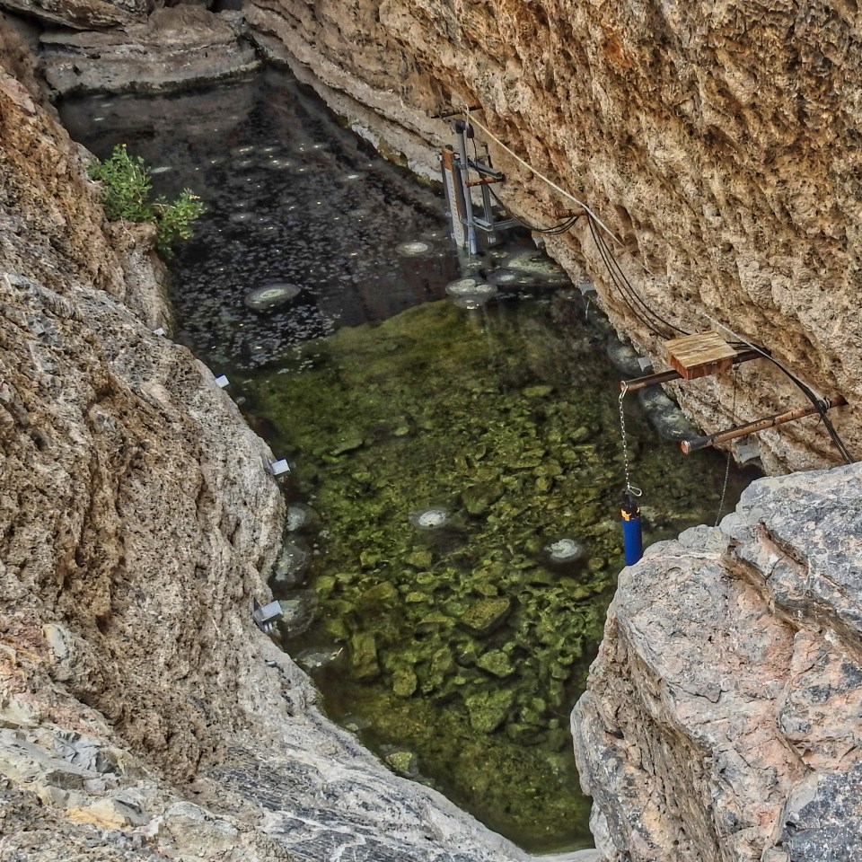 Monitoring equipment near water with rocky walls surrounding.
