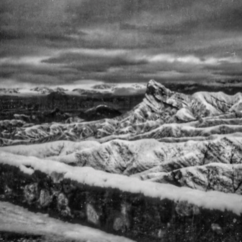 Rock wall and mountains covered with snow