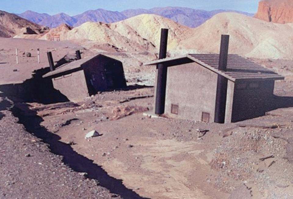 Concrete buildings in mud with mountains in background