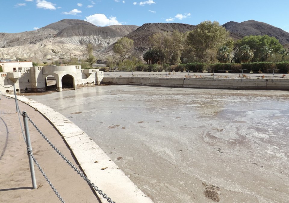 Large swimming pool filled with mud.