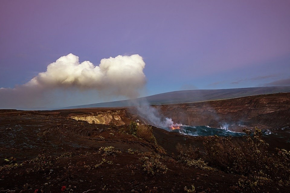 Lava erupting from a crater during the day.