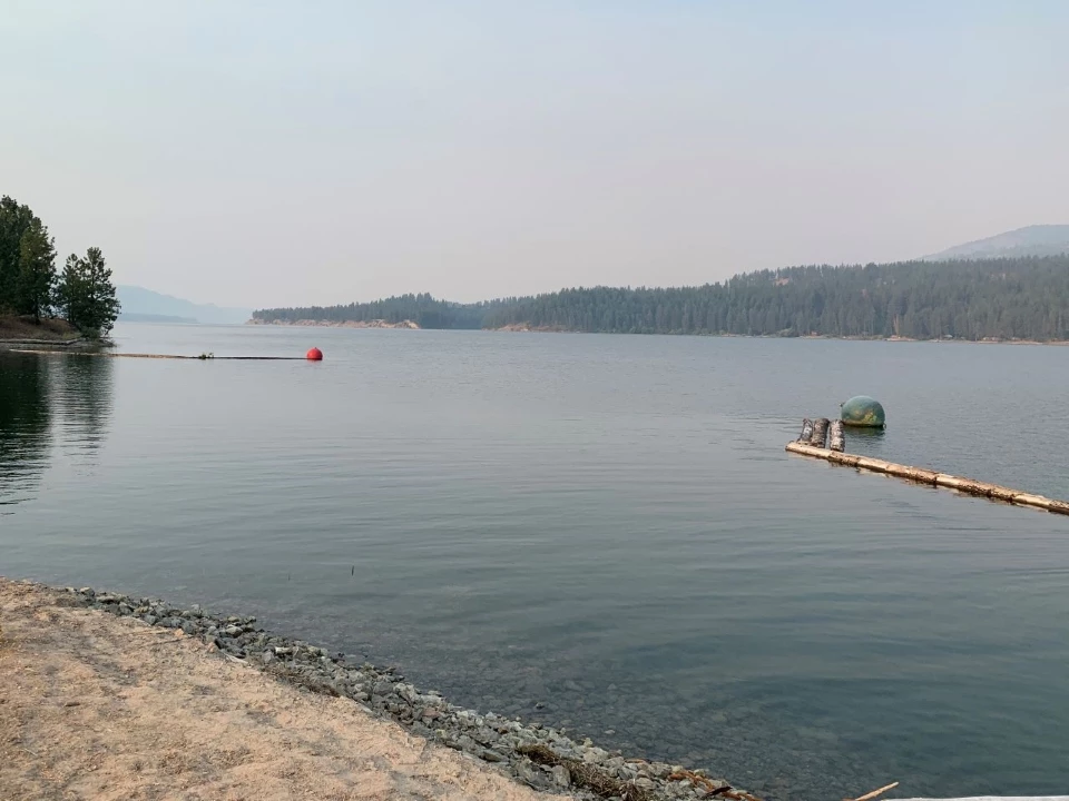 Fluffy white clouds overtop a reflective lake.