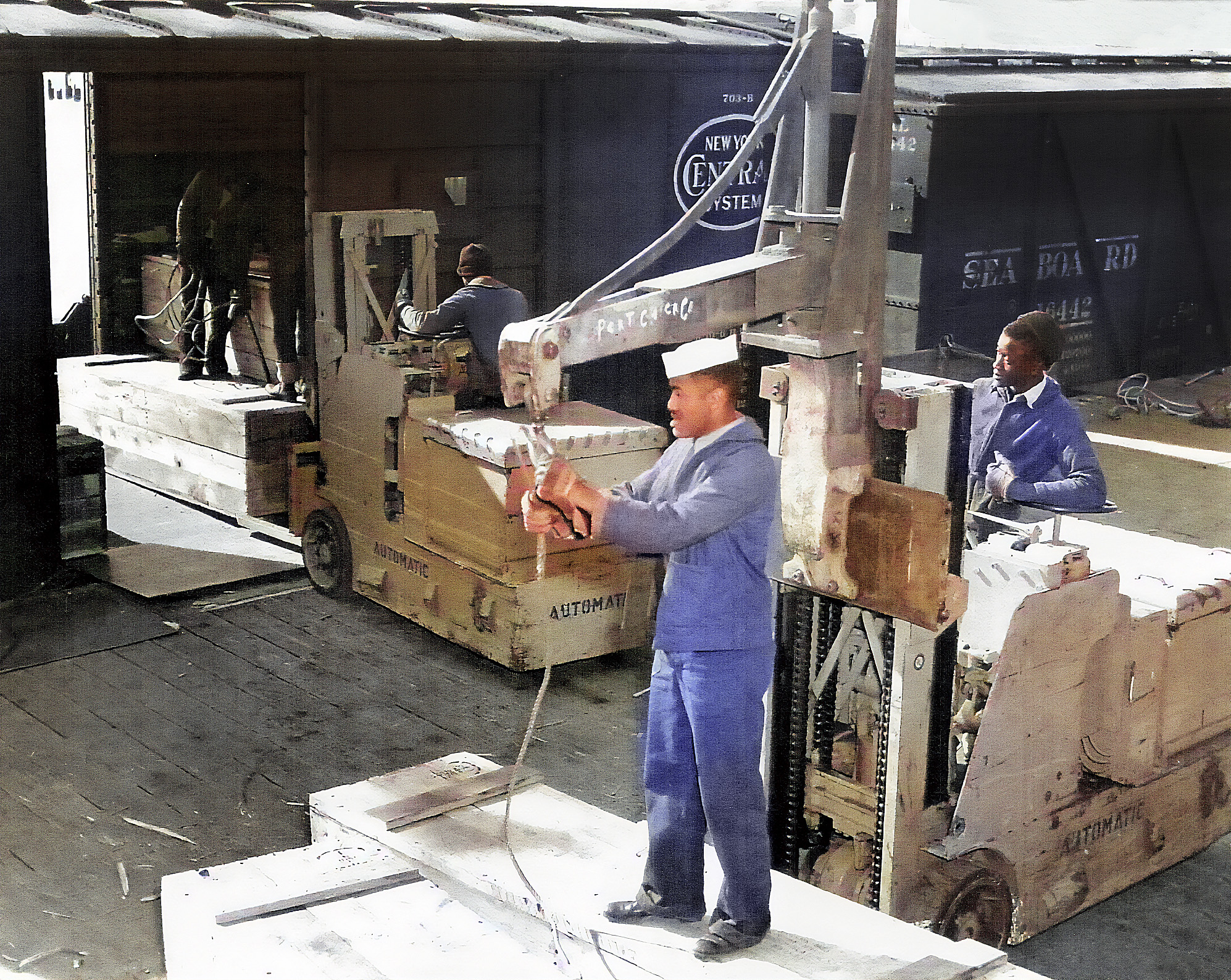 Historic Black and white photo of African American sailors loading munitions onto a rail car.
