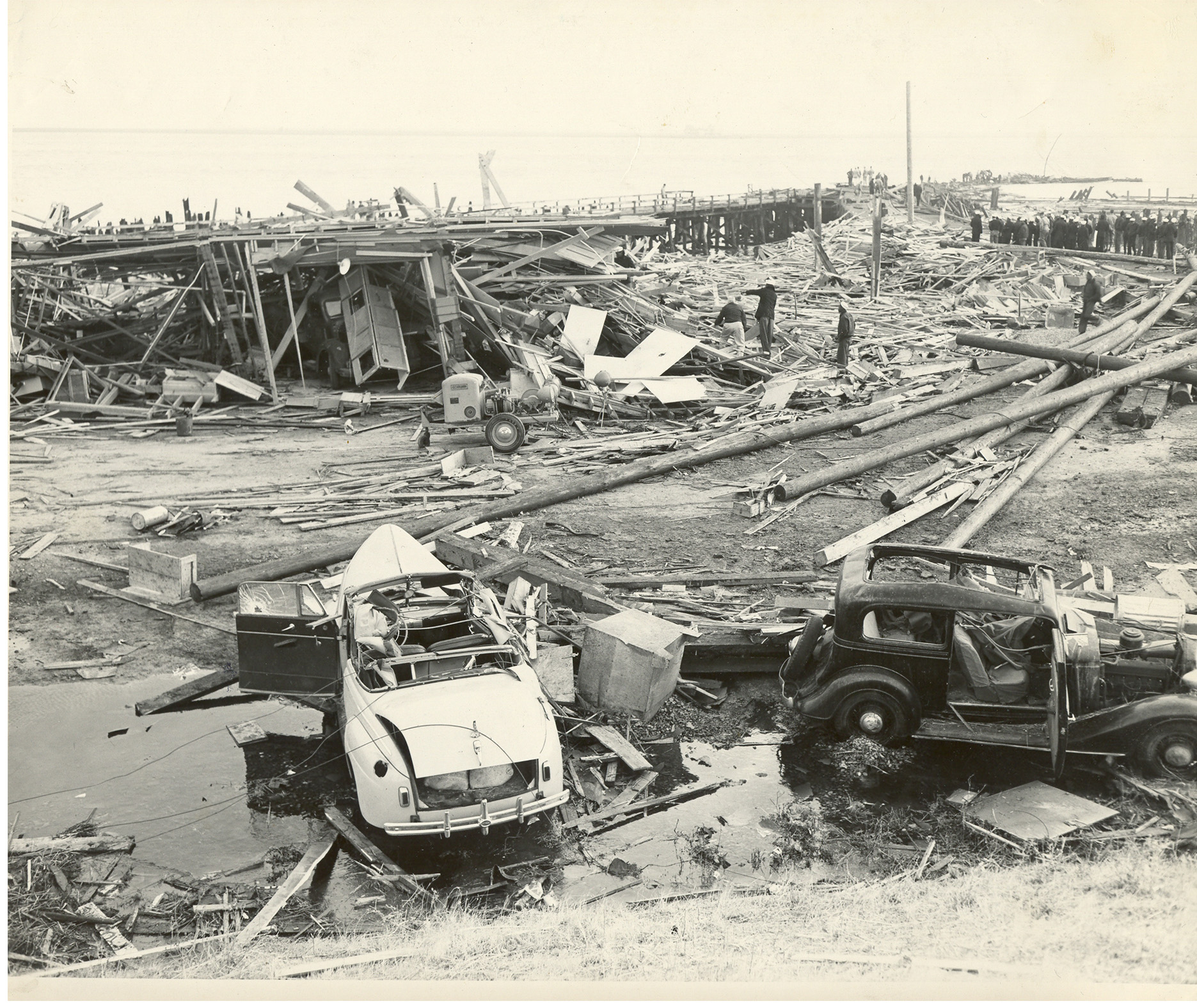Historic Black and white photo of the disaster aftermath. Two cars and a lot of debris from buildings.