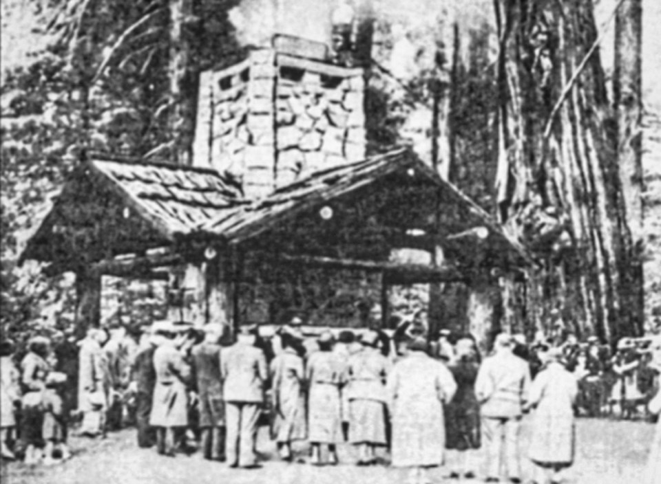Large group of people in front of building with redwoods