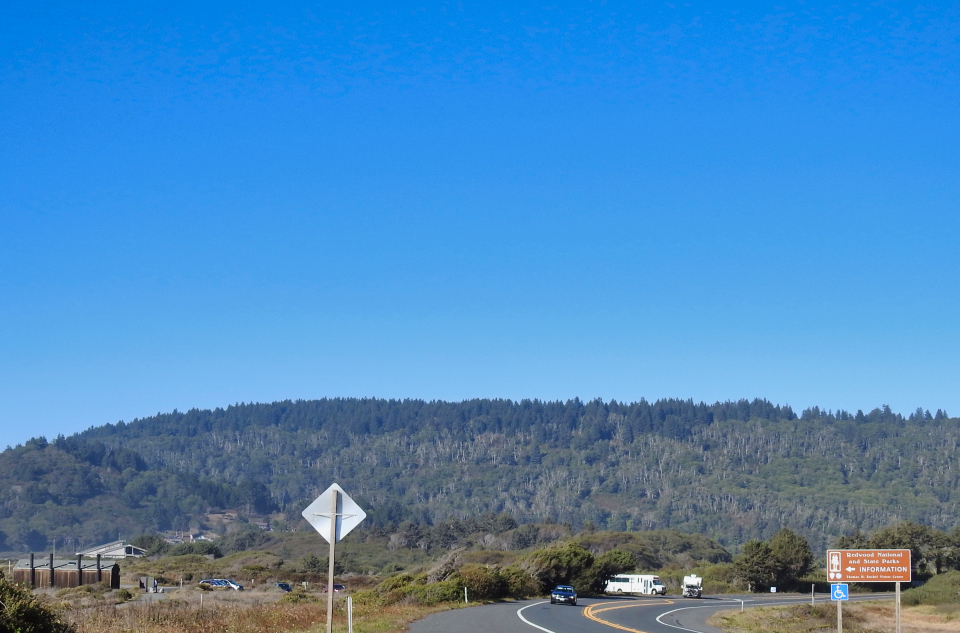 Lumber mill with steam rising, ridge in background
