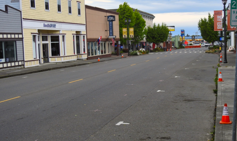People march in a large group down a city street.