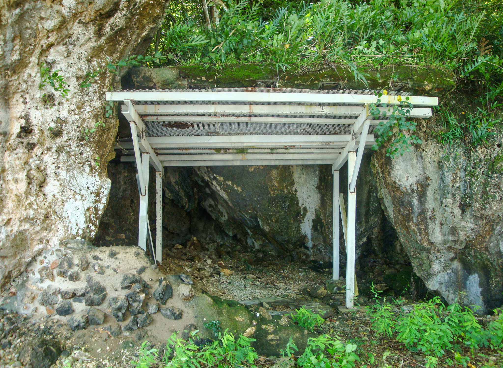 Black and white photo of a solider standing next to a bunker with a very large gun