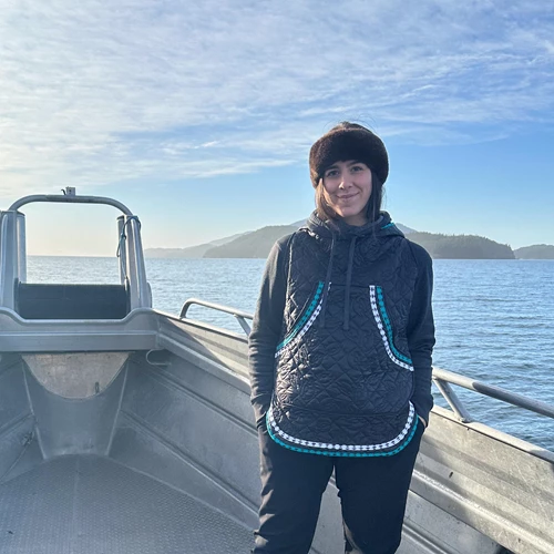 A woman stands on the deck of a boat