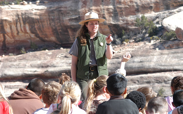 a park ranger stands in front of a group of students