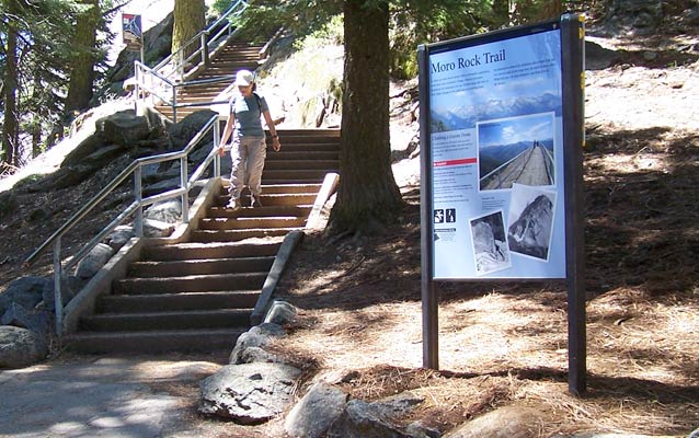 An upright orientation exhibit near a granite staircase