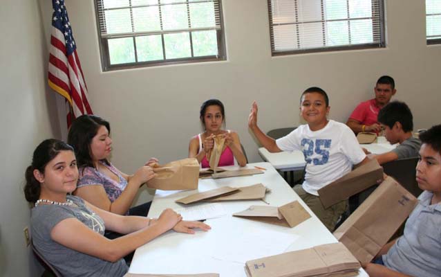 Youth from the Brownsville Housing Authority prepare luminarias for the annual Memorial Illumination.