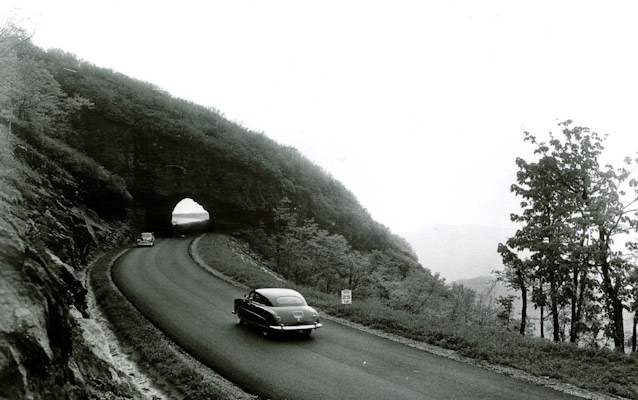 Historic photo from the mid 20th century of cars driving along the Blue Ridge Parkway.