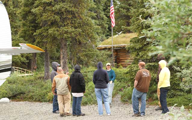 K. Schubeck, a volunteer at the remote Proenneke Historic Site for 13 years, gives a tour for wounded veterans and their spouses.